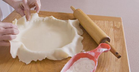 Kruimeldeeg maken: boter, suiker en eieren tot room kloppen, bloem toevoegen, opbollen, platdrukken en in plastiekfolie laten opstijven